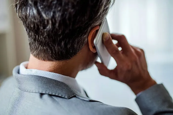Rear view of a businessman talking on a smartphone during his work routine.