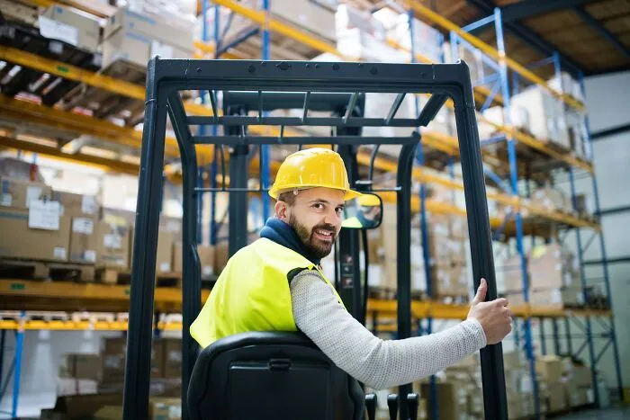 A warehouse worker operating a forklift where a single slip-up could cause damage