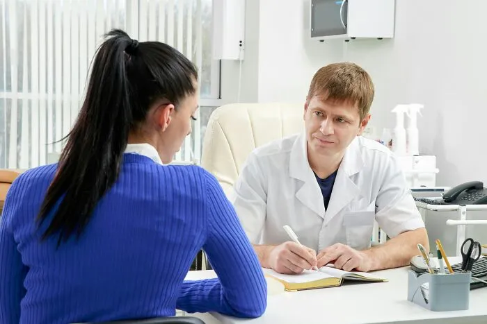 Woman consulting a male doctor in an office during medical appointment