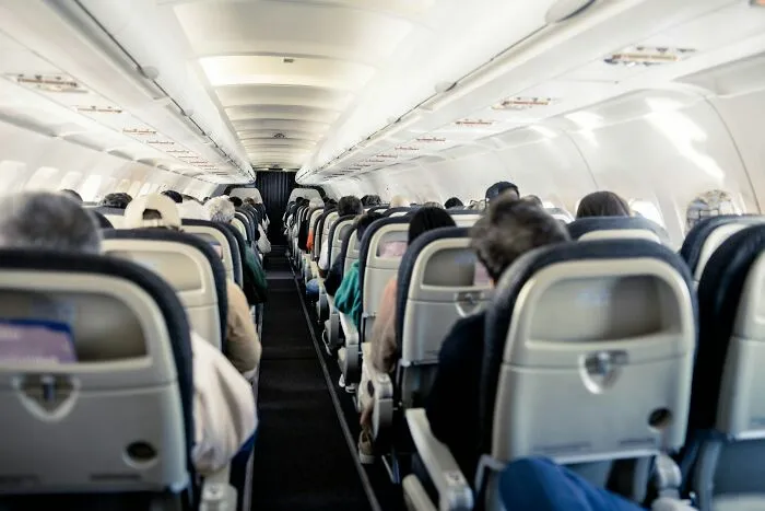 Passengers seated inside an airplane cabin waiting for flights