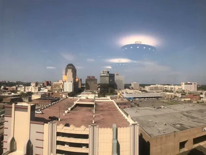 Ceiling light reflection looking like a UFO over a city skyline in a perfectly confusing photo.