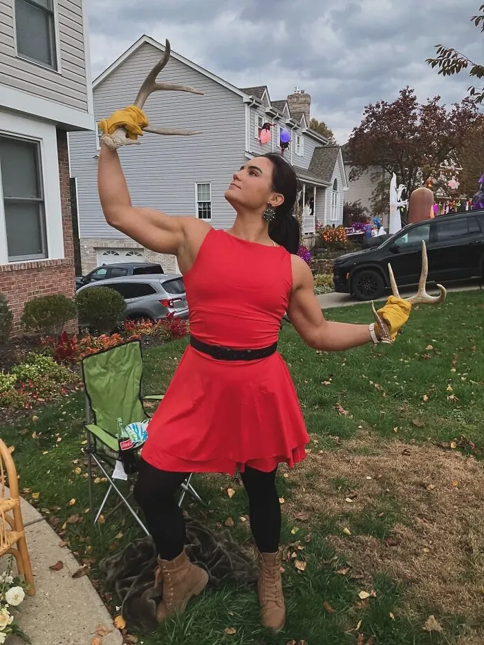 Athletic woman dressed as Gaston showing creative Halloween costume ideas outdoors