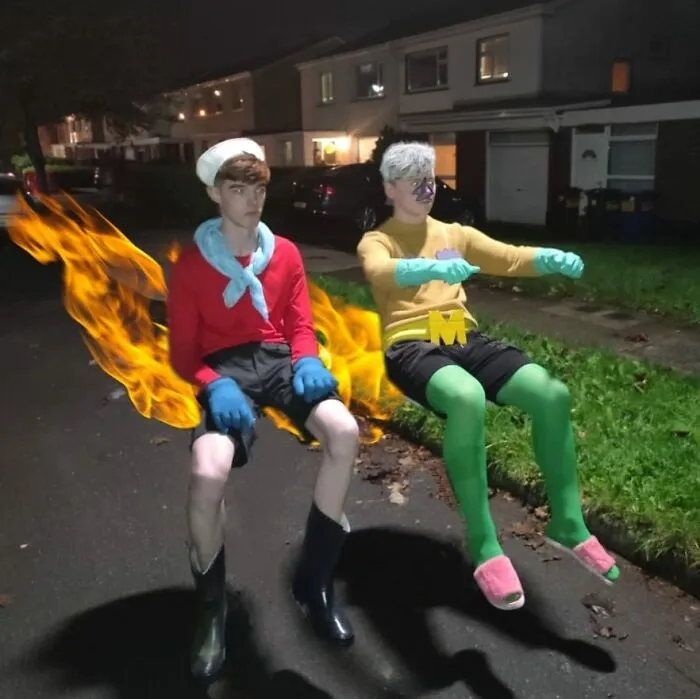 Two young men dressed as Mermaid Man and Barnacle Boy sitting on an invisible boatmobile for Halloween costume ideas.