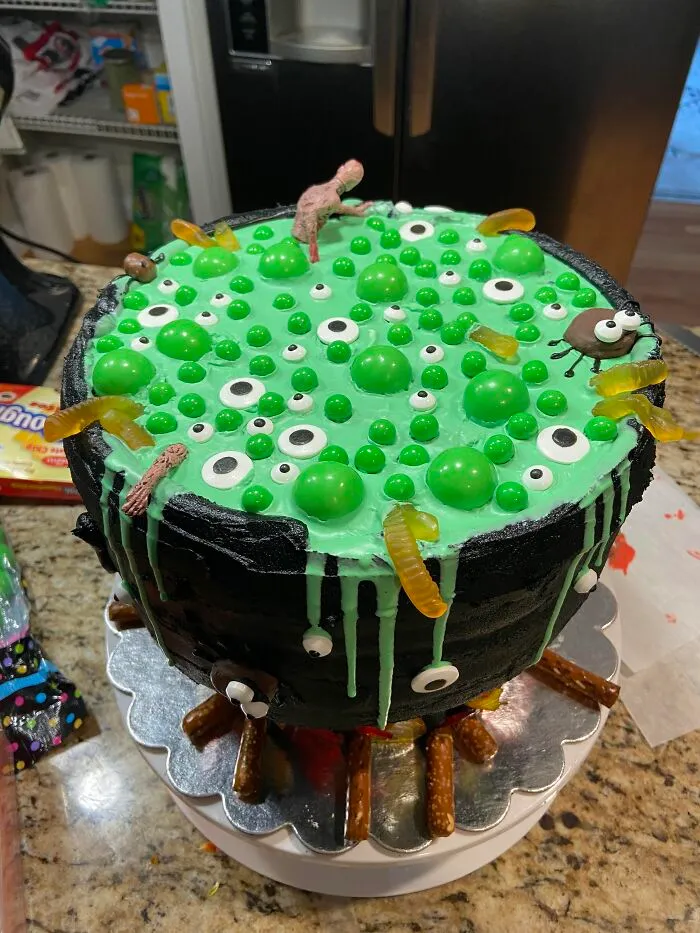 Witches cauldron cake topped with green slime and eyeballs as creative Halloween foods