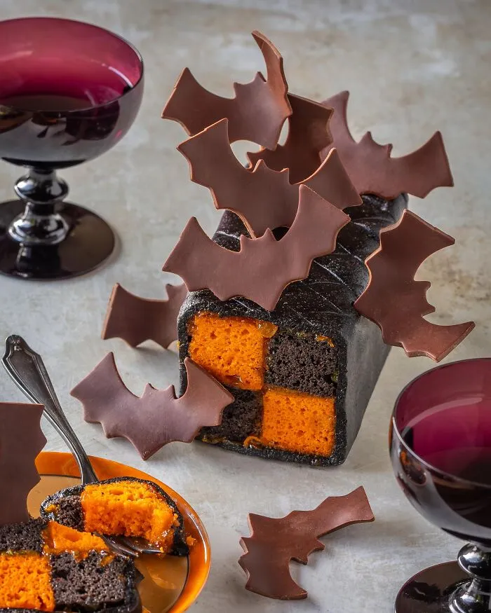 Checkered cake decorated with chocolate bats, perfect creative Halloween foods for parties.