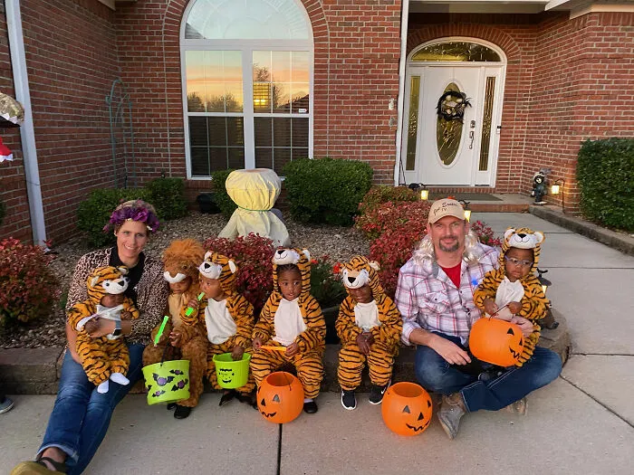 Family in Tiger King themed kids Halloween costumes sitting on a porch.