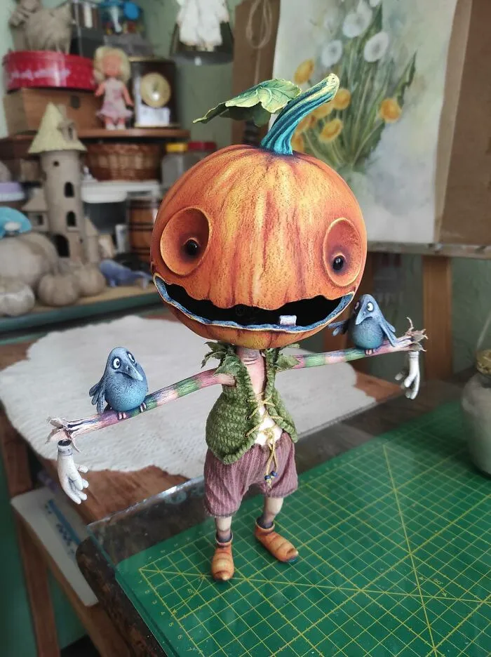 Handcrafted pumpkin scarecrow figurine with blue birds for Halloween home decor.
