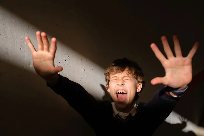 Child screaming and raising hands in a scared haunted house moment