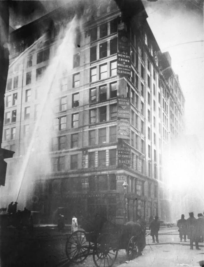 Firefighters spraying water on burning Asch Building, an example of small mistakes leading to disasters