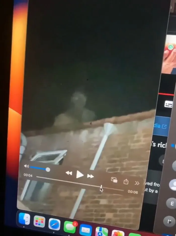 Computer screen displaying creepy photos of a dark figure standing on a roof at night