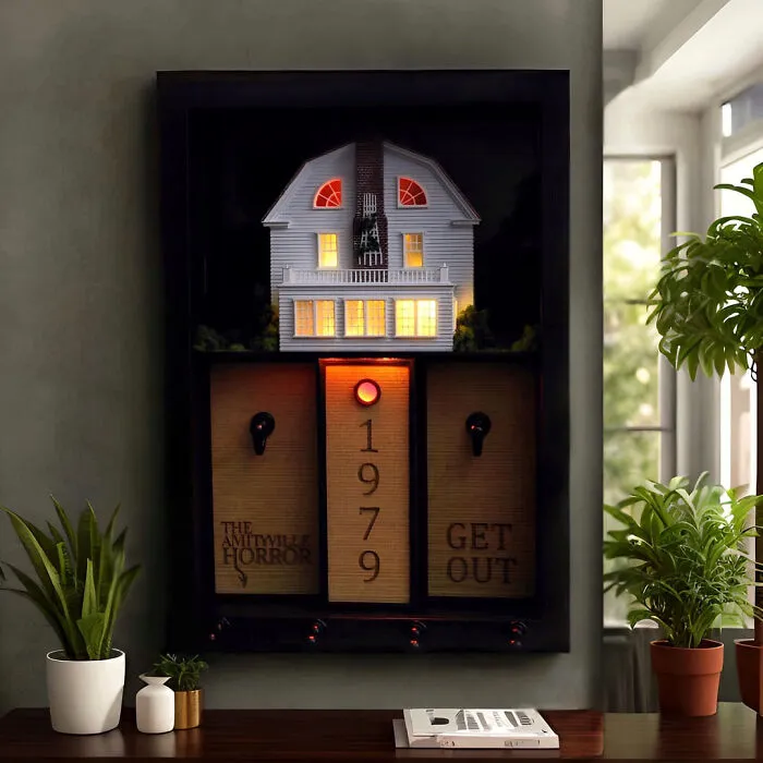 An Amityville Horror miniature house key holder displayed on a wall for spooky Halloween homes.
