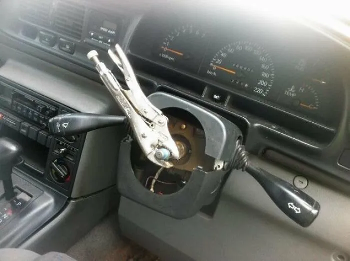 Redneck fixes showing locking pliers used as a makeshift steering wheel in a car.