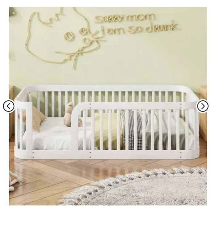 White toddler bed in a room with a decorative sign on the wall reading a funny inappropriate message.
