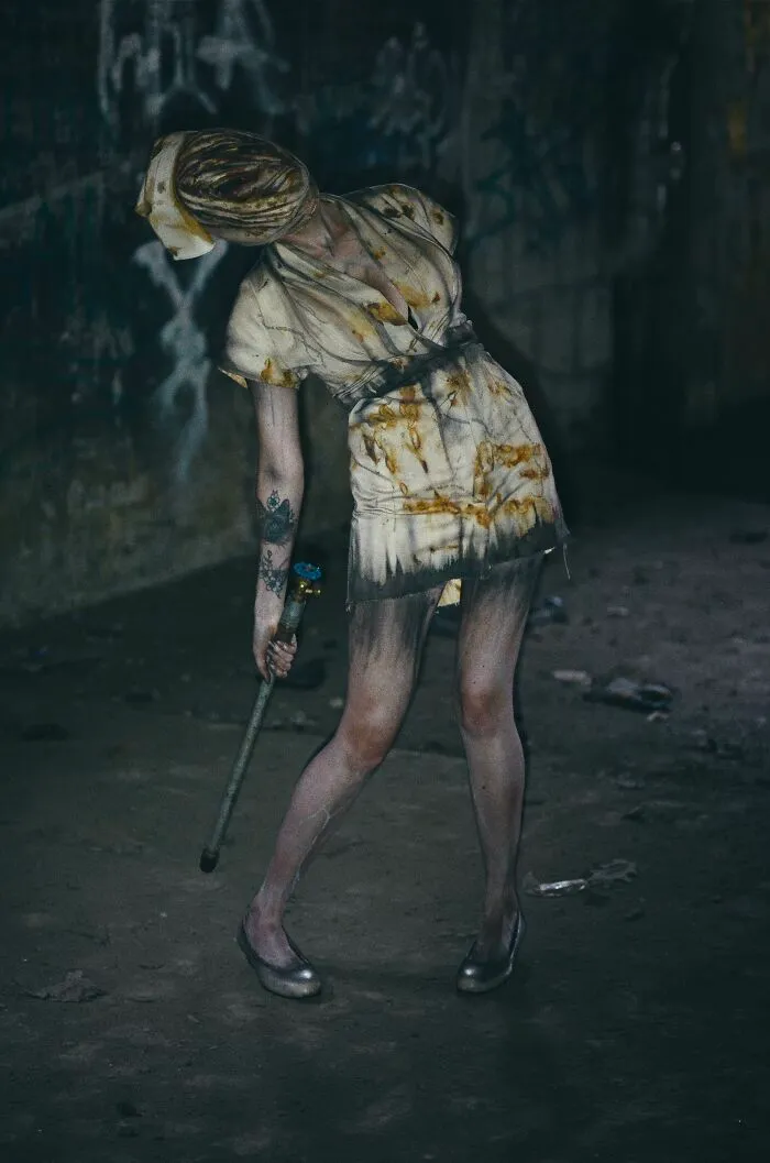 Creepy nurse in a stained outfit holding a pipe, perfect for creative Halloween costume ideas.