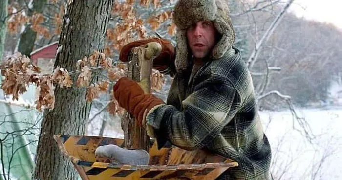 A man pushing a leg into a wood chipper, featuring movie props from Fargo