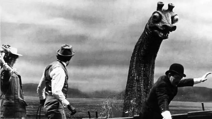 Vintage movie props showing a classic giant sea monster puppet next to actors in a boat