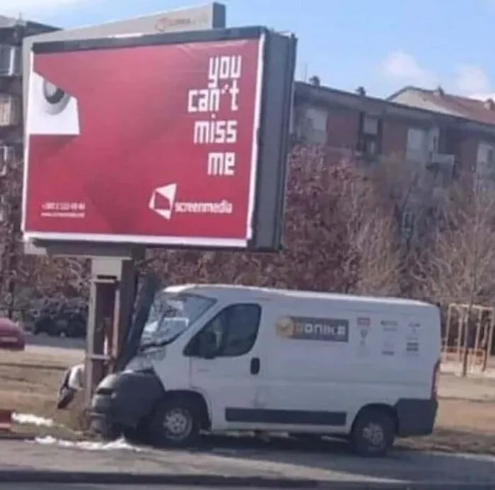 Humorous billboard meme saying you can't miss me with van crashed.