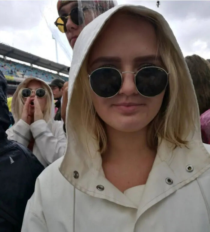 Woman in white hoodie and sunglasses with duplicate person behind glitch