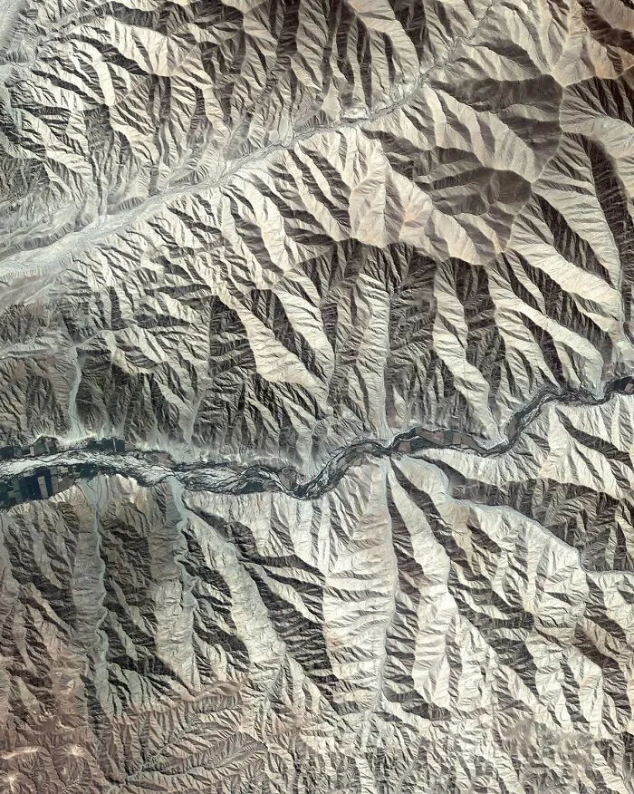 Surreal satellite photo featuring concentric geological rings in a desert landscape.