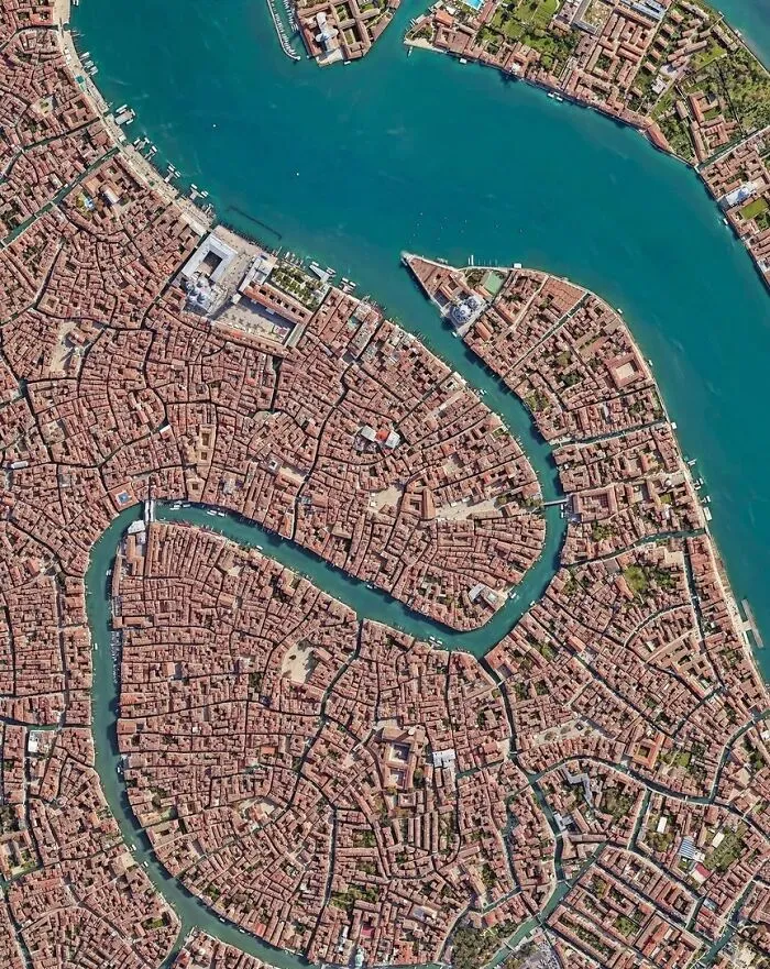 Aerial satellite photo of Venice canals and dense cityscape buildings.