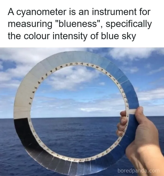 A hand holding a circular cyanometer against the ocean sky as an interesting fact about the world around us.