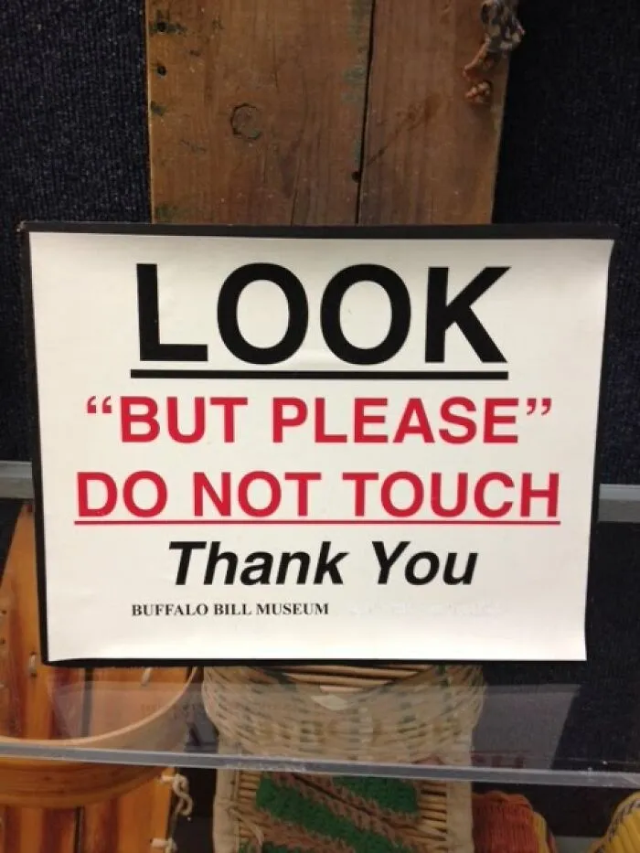 Museum sign misusing quotation marks around the words BUT PLEASE for do not touch warning.