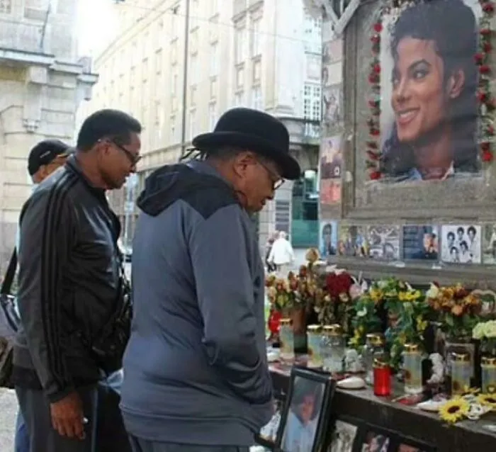 A man wearing a hat standing in front of a Michael Jackson memorial captured in photo for the last time