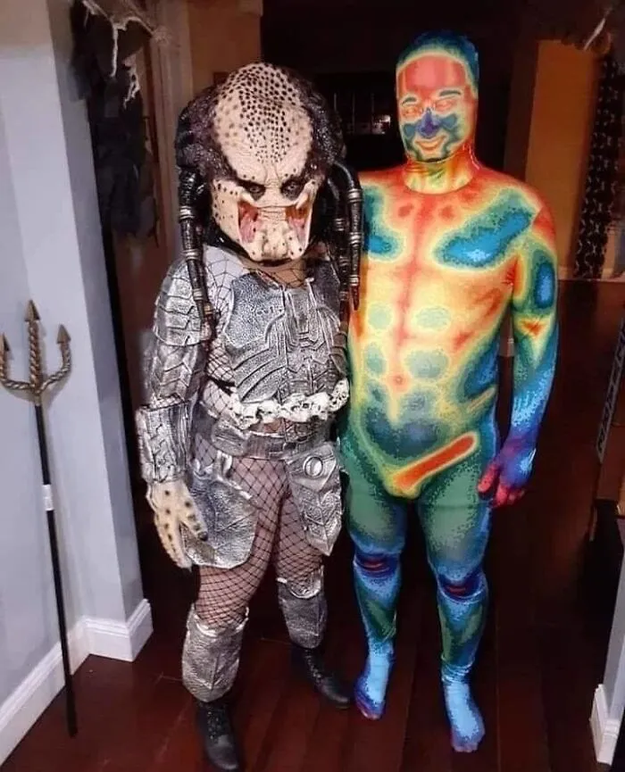 Creative Halloween couples costume featuring the Predator standing alongside a thermal vision heat map figure