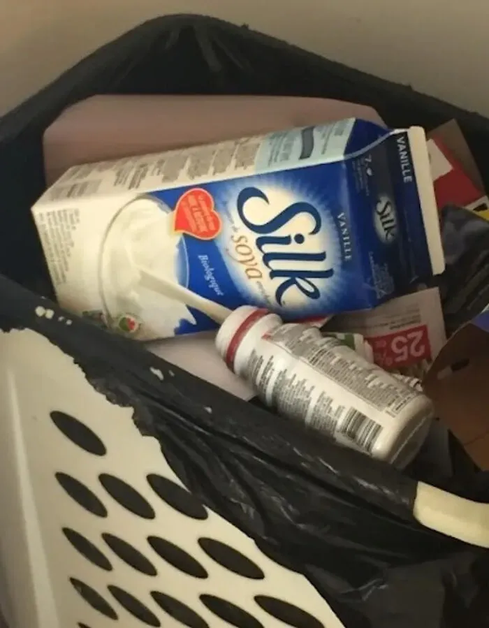 Opened Silk soy milk carton creating an optical illusion of pouring into a small bottle, making eyes play tricks.