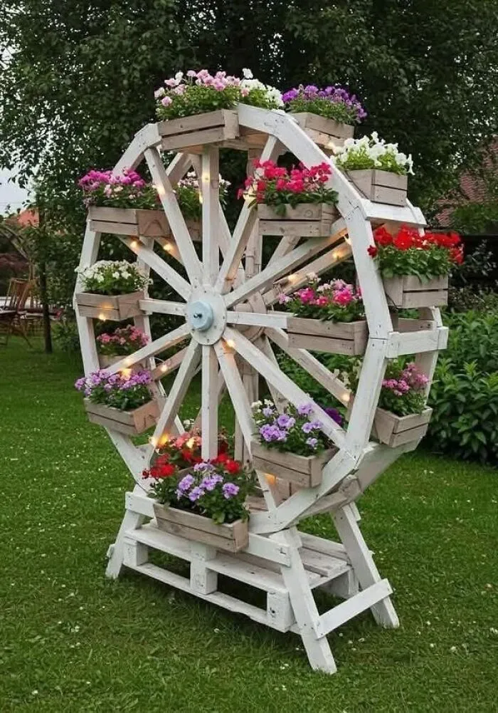 A decorative white ferris wheel planter in a garden, showing clever wooden creations