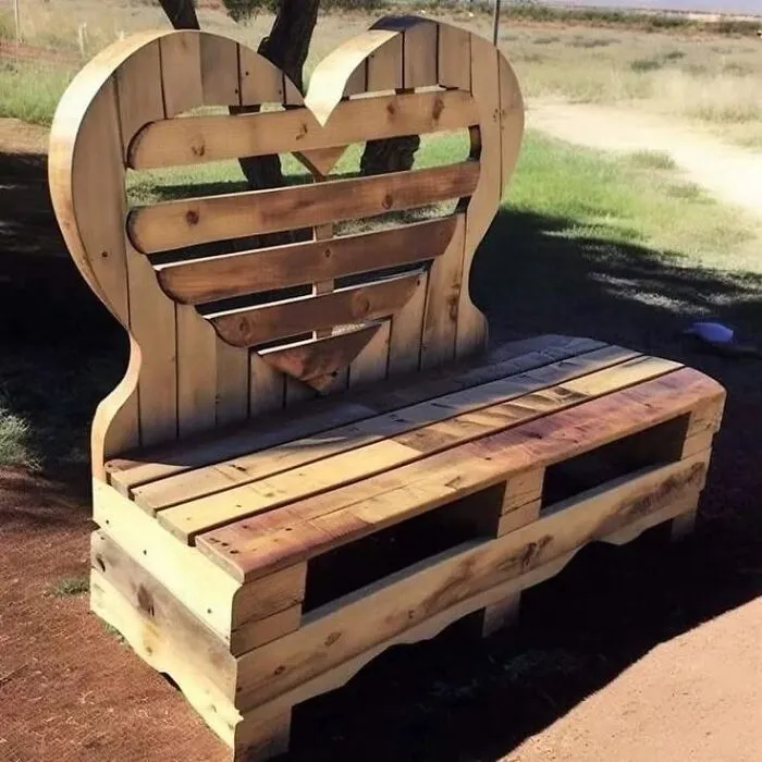 A rustic garden bench made from pallets, showing clever wooden creations shaped like a heart