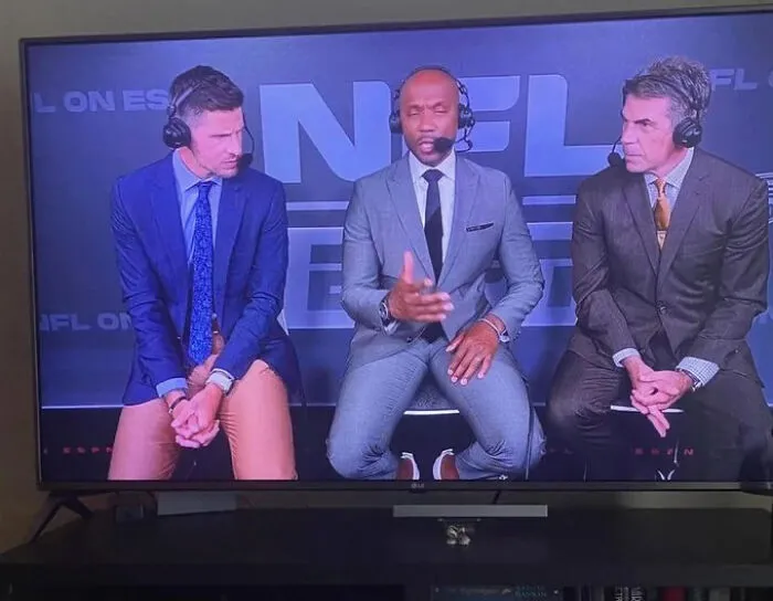 TV broadcast of sports commentators creating a confusing perspective illusion with their seating.