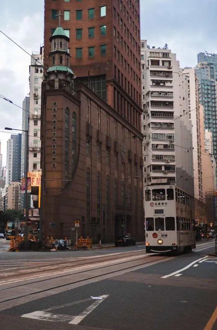 A narrow building in a city creating an optical illusion of being completely flat from this perspective.