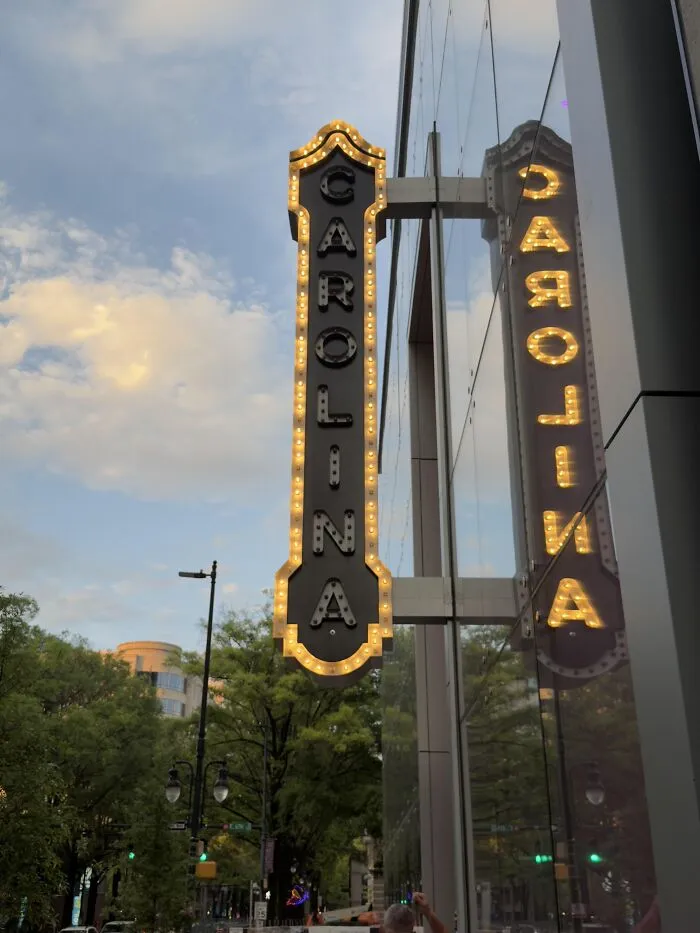 A glowing Carolina sign reflection creating photos that make you wonder if your eyes are playing tricks on you