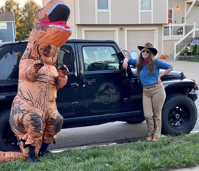 Person in an inflatable T-Rex suit next to someone dressed as a Jurassic Park ranger for funny cool Halloween couples costumes.