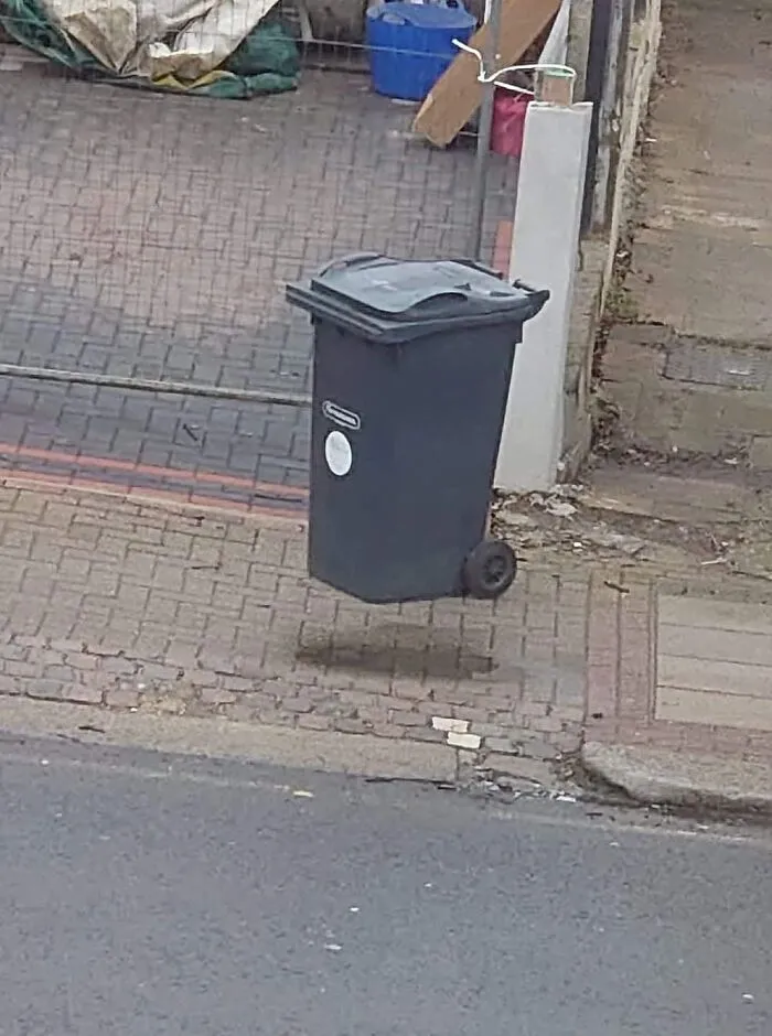 Photo trick showing a shadow under a trash bin making it appear to float in mid air