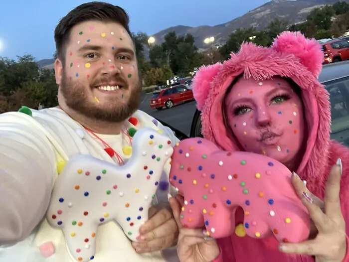 A smiling pair in circus animal cookie attire as funny cool Halloween couples costumes