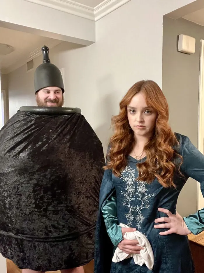 A man dressed as a large urn poses with a woman for funny Halloween couples costumes