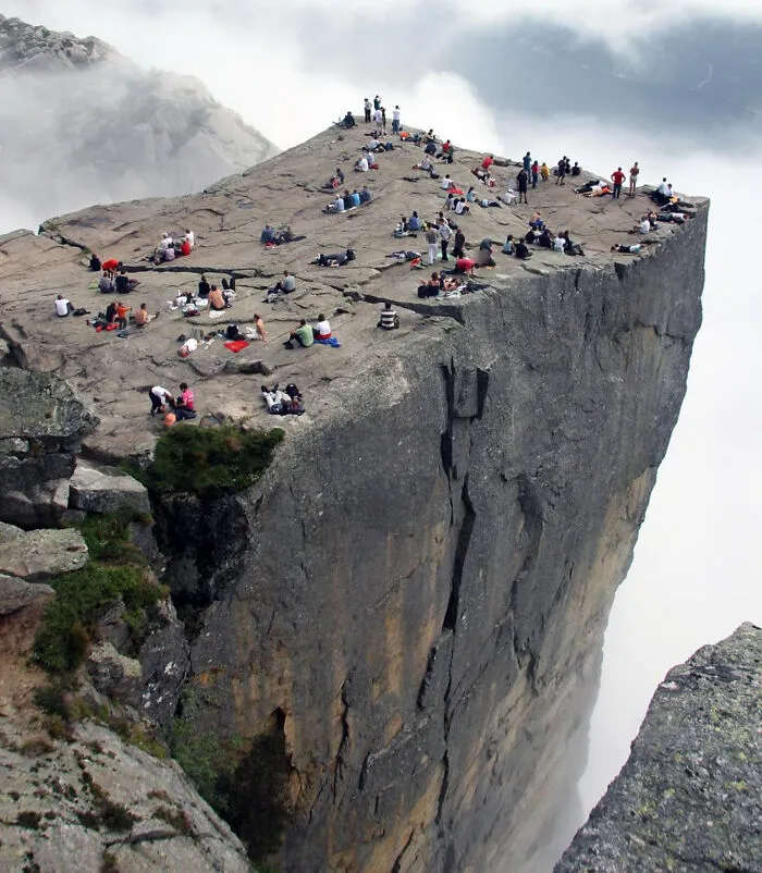 Perspective photo of people on Preikestolen cliff making it look like a sheer drop to test your eyes