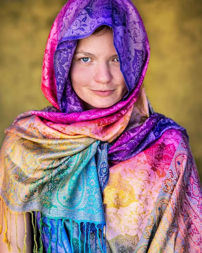 Beautiful portrait photos of a smiling woman with blue eyes wearing a colorful rainbow patterned headscarf
