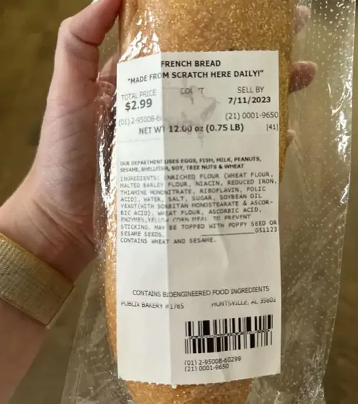 Hand holding a plastic bag of French bread, an example of annoying things partners do.