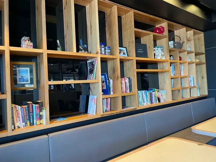 Large wooden bookshelf with compartments in a modern restaurant interior, highlighting useful and ingenious things.