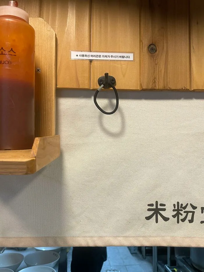 Black hair tie hanging on a wall hook in a restaurant, example of useful things in various parts of the world.