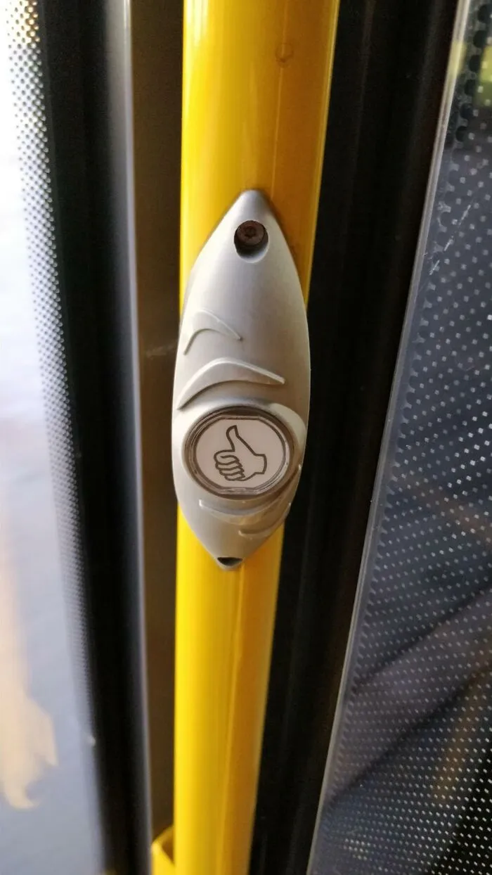 A bus stop request button with a thumbs-up icon, an ingenious thing used in public transport.