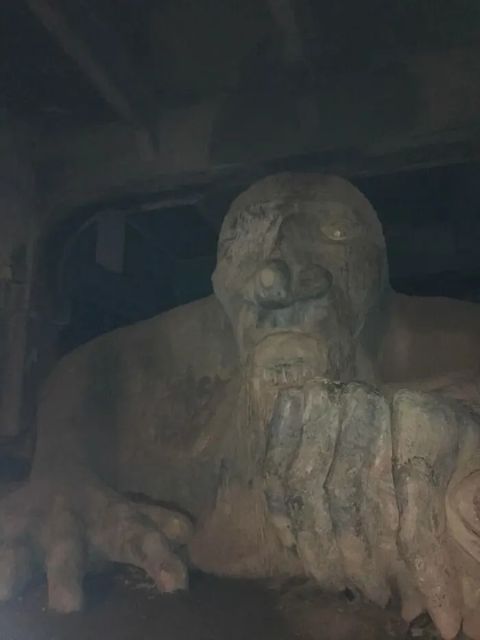A giant stone troll sculpture lurking in dark room featured in creepy photos