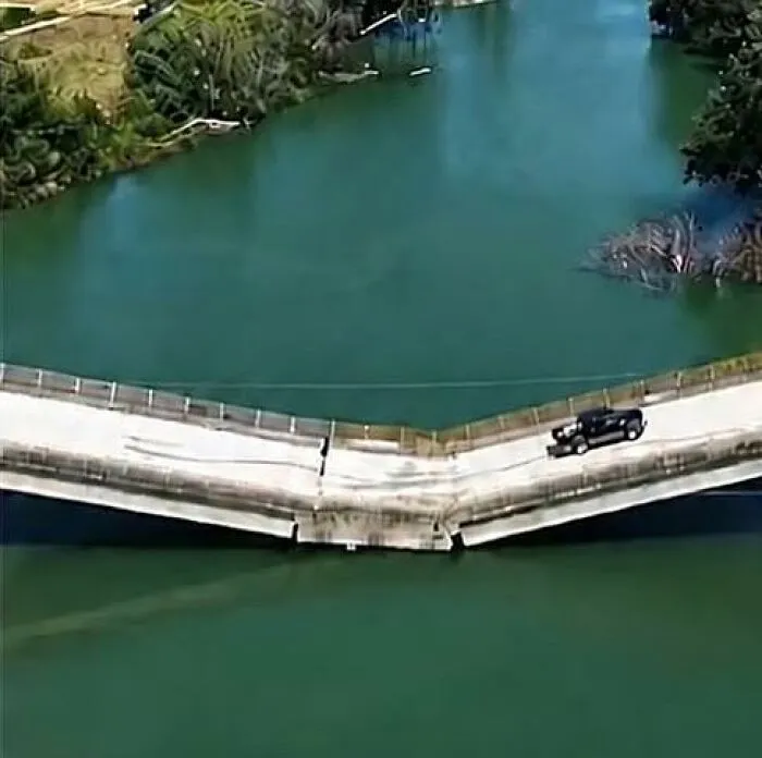 A collapsing bridge bowing severely under a truck in creepy photos.
