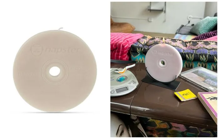 A CD-shaped wax candle inspired by early internet nostalgia brand Napster next to a retro disc player