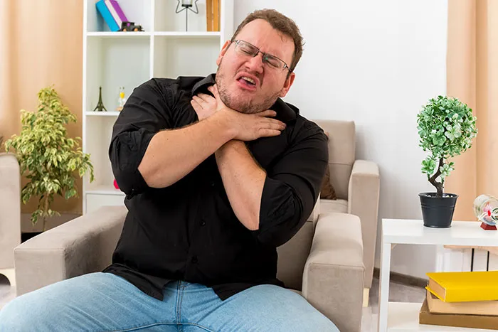Man clutching his neck in pain from a choking worst-case scenario