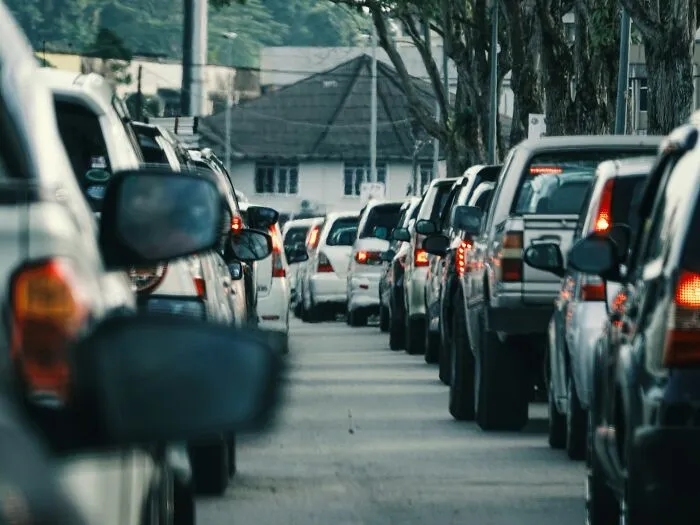 A long line of cars stuck in heavy traffic on an urban street, useful for emergency tips.
