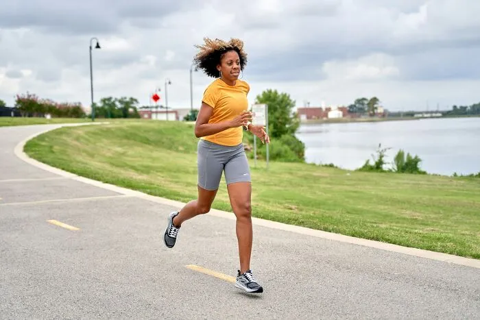 An athletic woman running outside, showcasing fitness and understanding of women's bodies.